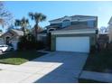 Home exterior showcasing a two-story facade with a two-car garage, palm trees, and a paved driveway at 2803 Lido Key Ct, Kissimmee, FL 34747