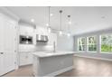 Bright kitchen featuring white cabinetry, stainless steel appliances, a marble island, and lots of natural light at 2975 Arranmore Dr, Ormond Beach, FL 32174