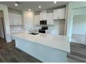 Modern kitchen with white cabinets, quartz countertops, and stainless steel appliances at 3238 Arch Ave, Ormond Beach, FL 32174