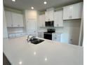 Modern kitchen with white cabinets, quartz countertops, and stainless steel appliances at 3238 Arch Ave, Ormond Beach, FL 32174