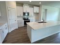 Modern kitchen with white cabinets, quartz countertops, and stainless steel appliances at 3238 Arch Ave, Ormond Beach, FL 32174