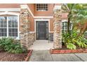 Front entrance with stone columns and a dark door at 351 Michigan Estates Cir, St Cloud, FL 34769