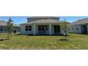This home features a covered back porch, sliding glass doors and manicured lawn at 5425 Log Grove Ln, Orlando, FL 32829