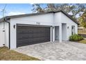 Modern house exterior with gray siding, dark gray garage door, and paved driveway at 722 W Kaley Ave, Orlando, FL 32805