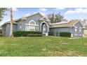 Gray house with a green lawn, walkway, and solar panels at 728 Longford Loop, Apopka, FL 32703