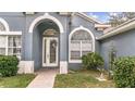 Front entryway with arched windows and a glass door at 728 Longford Loop, Apopka, FL 32703