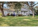 Gray house with white trim, front porch, and large yard at 860 Oak Dr, Groveland, FL 34736
