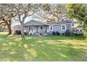 Gray house with white trim, front porch, and large yard at 860 Oak Dr, Groveland, FL 34736