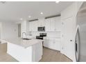 Modern kitchen with white cabinets, stainless steel appliances, and an island at 1365 Hanoverian Dr, Lake Alfred, FL 33850