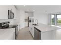 Modern kitchen with white cabinets, stainless steel appliances, and an island at 1365 Hanoverian Dr, Lake Alfred, FL 33850