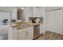 Kitchen with double sink, granite countertops, and white cabinets at 142 Southern Pecan Cir # 207, Winter Garden, FL 34787