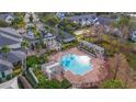 Aerial view of community pool with surrounding patio and landscaping at 142 Southern Pecan Cir # 207, Winter Garden, FL 34787