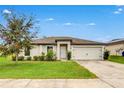 Inviting single-story home featuring a well-maintained lawn, enhanced curb appeal and attached garage at 1952 Piedmont Ct, Mascotte, FL 34753
