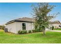 Exterior view of a single-story home showing the lawn, landscaping, and architectural design elements at 1952 Piedmont Ct, Mascotte, FL 34753
