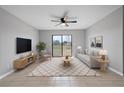 Bright living room featuring stylish furniture, a ceiling fan, and sliding glass doors at 1952 Piedmont Ct, Mascotte, FL 34753