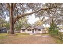 House with a large front yard, featuring mature oak trees with Spanish moss at 308 Wade Ave, Deland, FL 32724