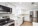 Modern kitchen featuring white shaker cabinets, stainless steel appliances, and quartz countertops at 308 Wade Ave, Deland, FL 32724