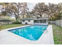 Inviting rectangular swimming pool with a screened enclosure in a fenced backyard at 308 Wade Ave, Deland, FL 32724