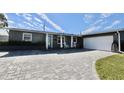 Ranch-style home with gray siding, white garage, and paver driveway at 326 Benton St, Orlando, FL 32839