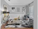 Cozy living room with decorative furniture, modern art, and a stylish mirror, creating an inviting atmosphere at 3689 Rolling Hills Ln, Apopka, FL 32712
