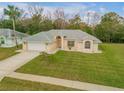 Aerial view of a single-story house with a spacious front yard and driveway at 4572 Woodcove Dr, Port Orange, FL 32127