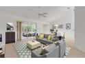 Bright living room featuring gray sofa, yellow pillows, and access to a relaxing patio at 4572 Woodcove Dr, Port Orange, FL 32127