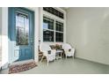 Welcoming front porch with teal door and wicker chairs at 7836 Crosswinds Way, Mount Dora, FL 32757