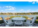 White wicker patio furniture overlooking a peaceful lake at 7836 Crosswinds Way, Mount Dora, FL 32757