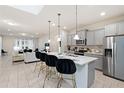 Modern kitchen with gray cabinets, quartz counters, and breakfast bar at 8906 Zurich Ln, Kissimmee, FL 34747