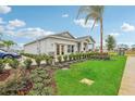 Front view of a one-story home with a two-car garage, landscaping, and a palm tree at 9158 Harris Hawk Dr, Leesburg, FL 34788