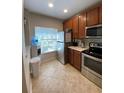 Modern kitchen with stainless steel appliances and wood cabinets at 10433 Manderley Way # 267, Orlando, FL 32829