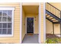 Apartment entrance featuring a black door and small window on a building with yellow siding at 1057 S Hiawassee Rd # 1911, Orlando, FL 32835