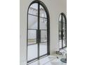 Elegant arched double doors with black frames and glass panes at 11030 Bridge House Rd, Windermere, FL 34786