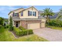 Two-story home with a three-car garage, stone accents, and well-maintained landscaping at 1416 Cabot Dr, Clermont, FL 34711