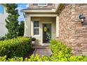 Inviting front entrance with a wreath, stone accents, and lush landscaping at 1416 Cabot Dr, Clermont, FL 34711