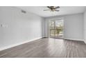 Bright, airy bedroom with vinyl flooring, ceiling fan, neutral walls, and balcony access at 1932 Lake Atriums Cir # 69, Orlando, FL 32839