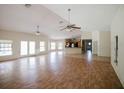 Large, open-concept living area with hardwood floors, multiple windows, and ceiling fans for added comfort at 585 Gasline Rd, Deland, FL 32724