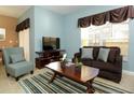Cozy living room featuring a brown sofa and striped rug at 8938 Majesty Palm Rd, Kissimmee, FL 34747
