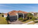 House with tile roof and landscaping, viewed from the street at 13370 Alderley Dr, Orlando, FL 32832