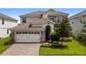 Two-story house with stone accents and a three-car garage at 1555 Palmero Way, Davenport, FL 33896