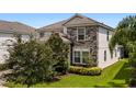 Two story house with stone accents and lush landscaping at 1555 Palmero Way, Davenport, FL 33896