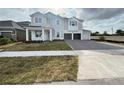 Two-story home featuring a light gray exterior, a brick paved driveway, and an attached two-car garage at 2726 Ravencliffe Ter, Oviedo, FL 32765