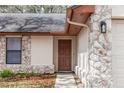 Inviting front entry featuring a stone facade, brown door, and well-maintained landscaping at 512 Holbrook Cir, Lake Mary, FL 32746