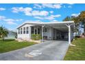 Single-wide manufactured home with carport, landscaping, and driveway at 6375 Lolly Bay Ne Loop, Winter Haven, FL 33881
