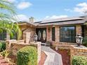 Inviting front entrance with brick accents, decorative plants, and glass-paneled double doors at 647 Saranac Dr, Winter Springs, FL 32708