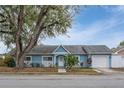 Light blue house with a white garage door and landscaping at 8465 Oak Bluff Dr, Orlando, FL 32827