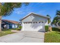 Gray house with white garage door and landscaping at 1511 Oak Hill Trl, Kissimmee, FL 34747