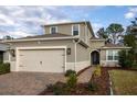 Charming gray home with a well-manicured lawn, lovely landscaping, and a spacious two car garage at 223 Cherokee Hill, Deland, FL 32724