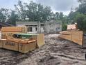 New home construction site with piles of lumber and building materials waiting to be put to use in construction at 25122 Ensley Rd, Sorrento, FL 32776