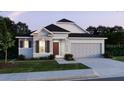 Charming single-Gathering home showcasing stone accents, a two-car garage, and a well-maintained lawn at 25122 Ensley Rd, Sorrento, FL 32776